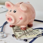 Funny piggybank standing on clipboard with document