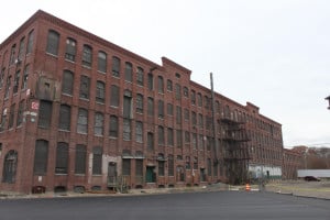 Boston-based Trinity Financial plans to redevelop the Van Brodie Mill in Lawrence into a 102-unit mixed-income housing project. But first, it’ll have to redevelop three vacant multifamily properties as part of an anti-blight program.
