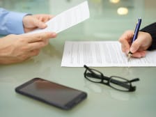 businessman and woman are reading and signing contract